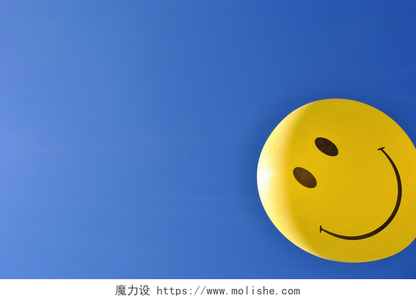 蓝天上的黄色笑脸气球微笑的脸